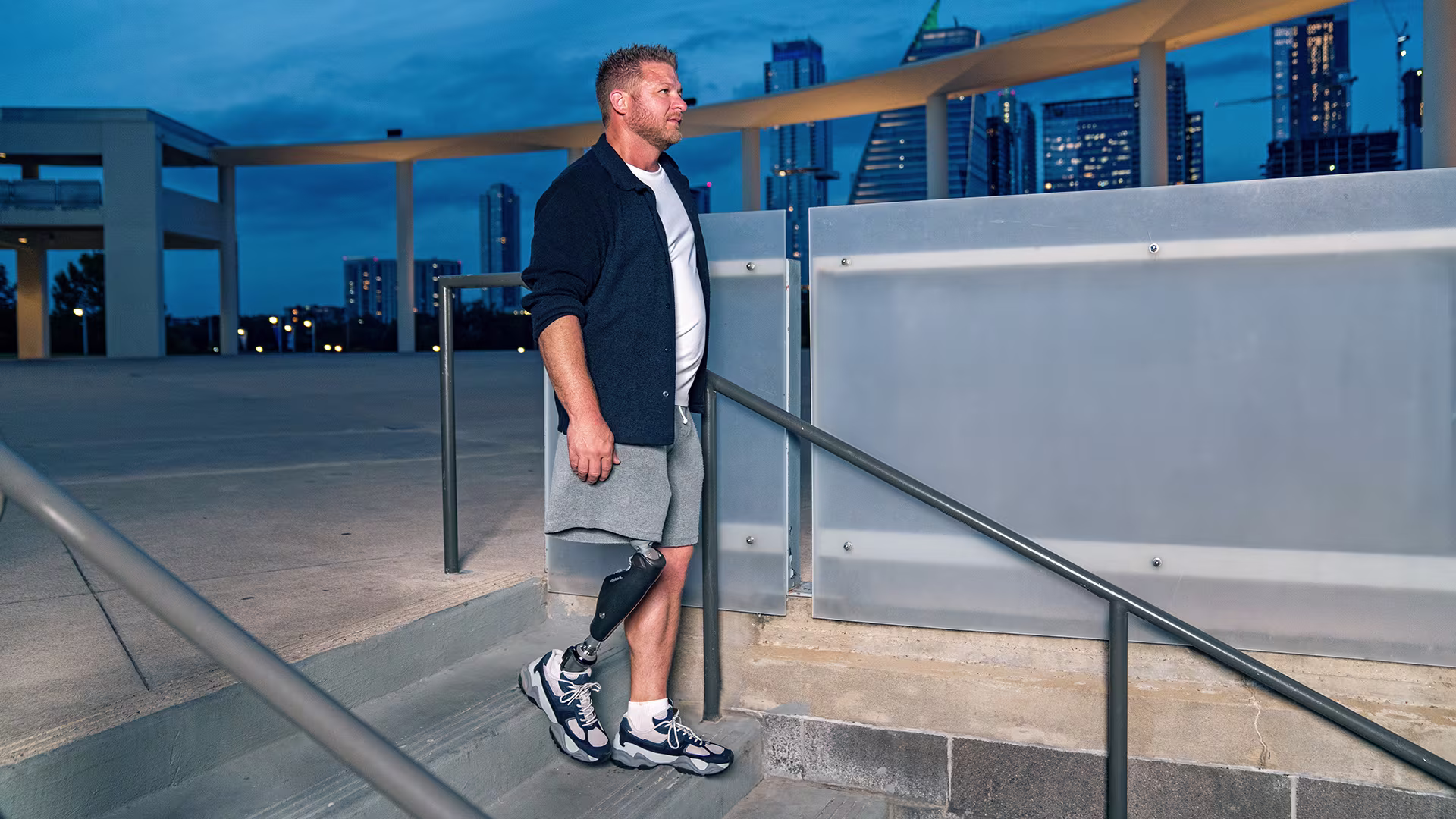 A male C-Leg user walks down a flight of stairs.