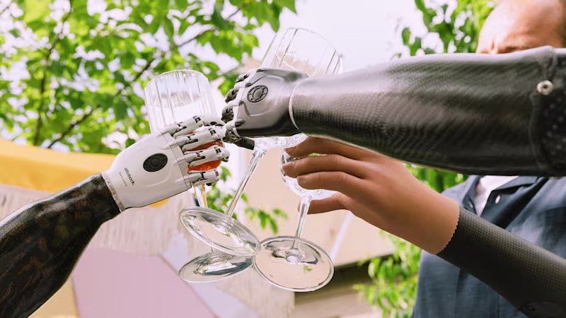 Ottobock prosthetic arm users, wearing bebionic hand and Speed Hand, toasting.