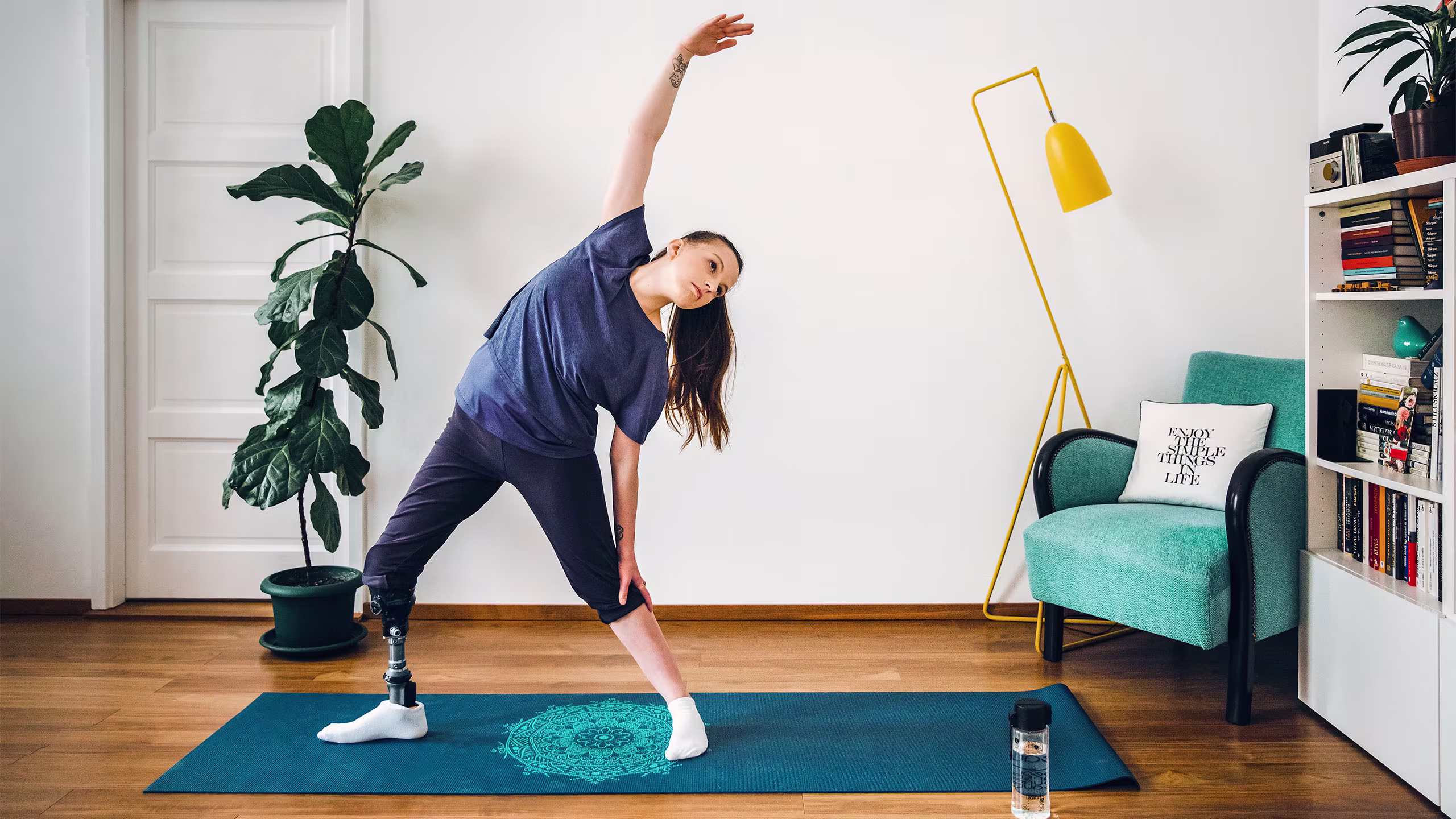 Daniella con il piede protesico Taleo Vertical Shock fa yoga in casa sul tappe