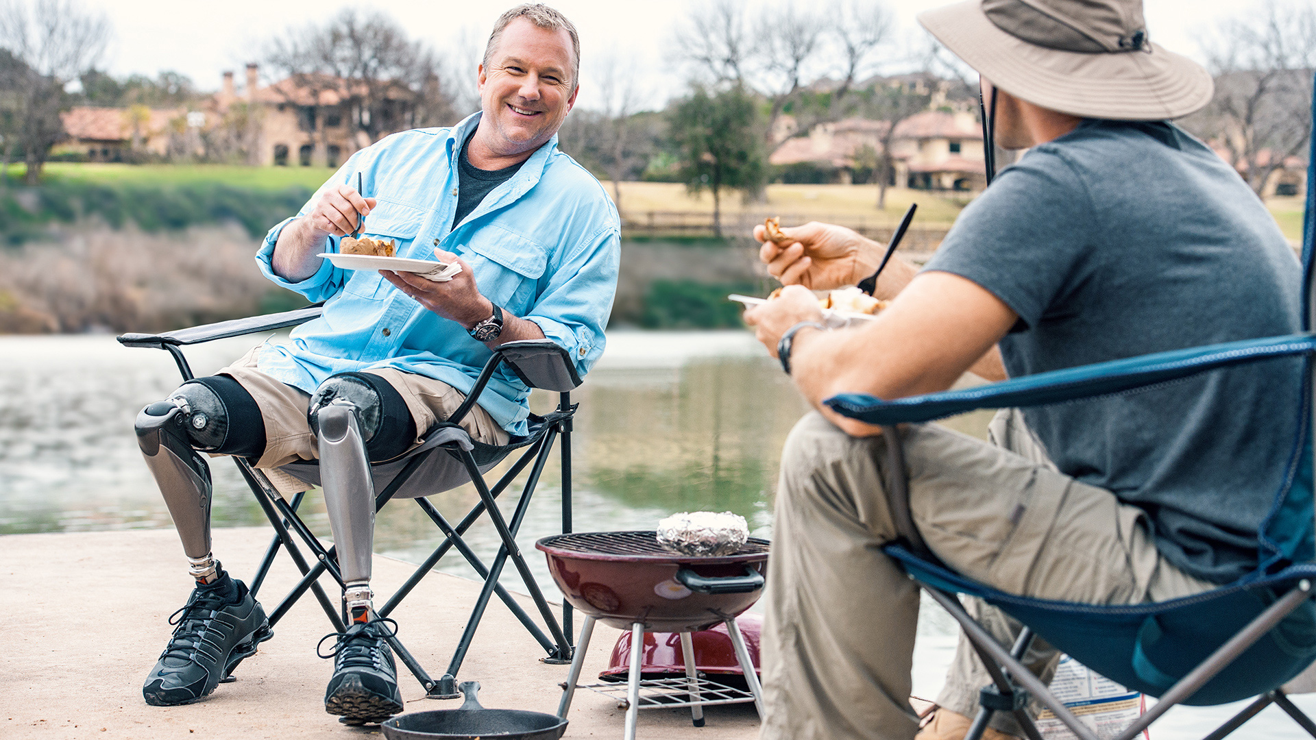 A bilateral Ottobock Genium X4 user walking on the beach with his daughter.