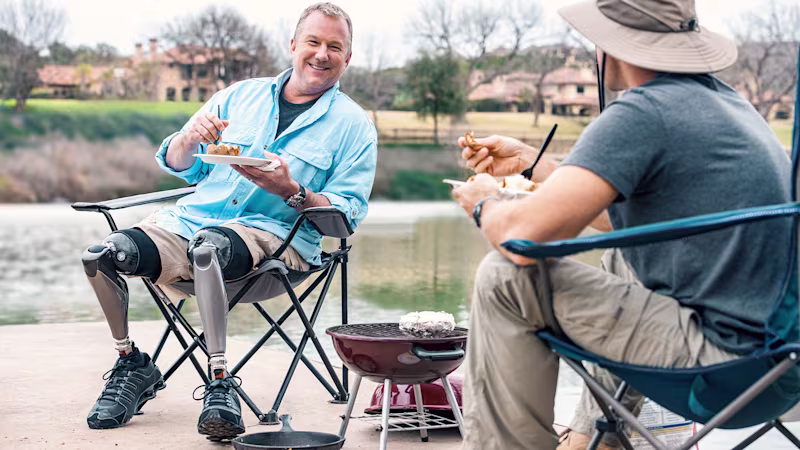 A bilateral Ottobock Genium X4 user walking on the beach with his daughter.
