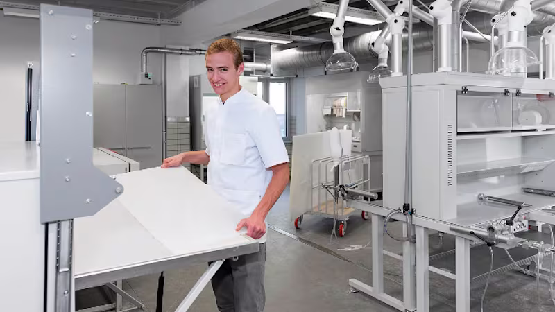 Ein Techniker steht in einer Werkstatt und arbeitet mit einem Material von Ottobock.