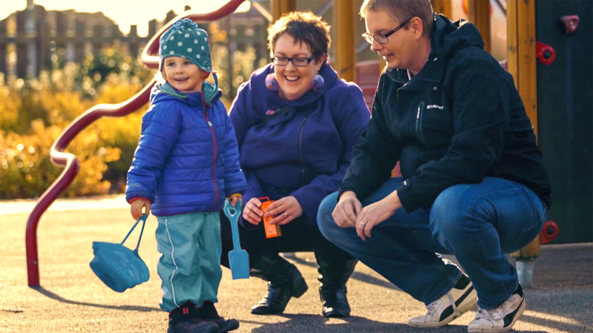 Child wearing an Ottobock hand prosthesis together with his parents.
