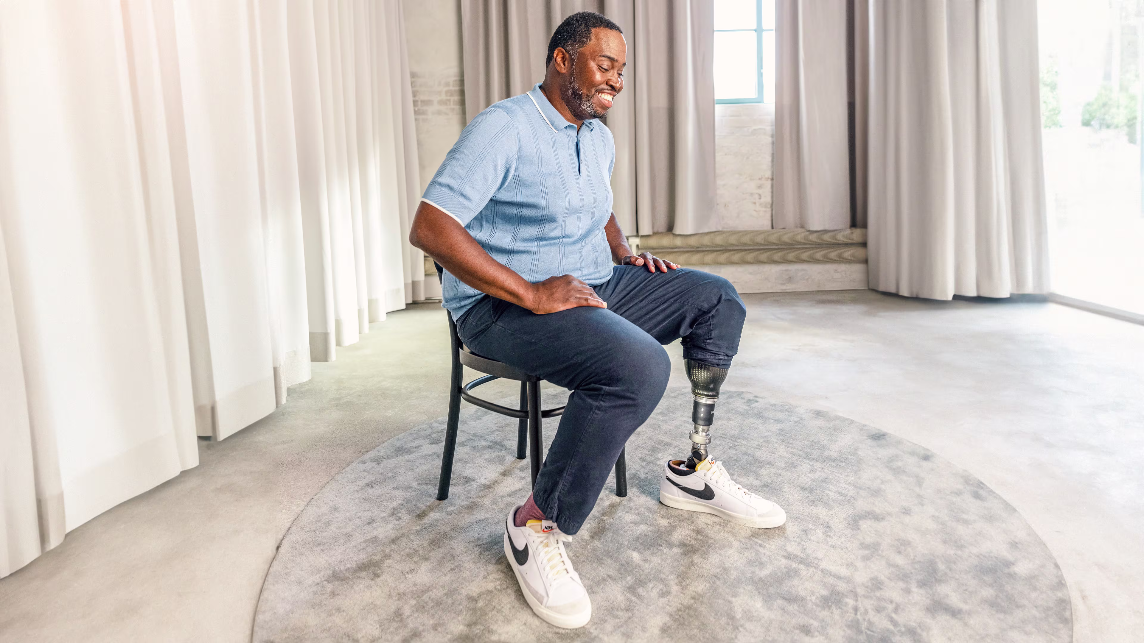 A man with the Taleo Adapt hydraulic prosthetic foot is sitting on a chair. 