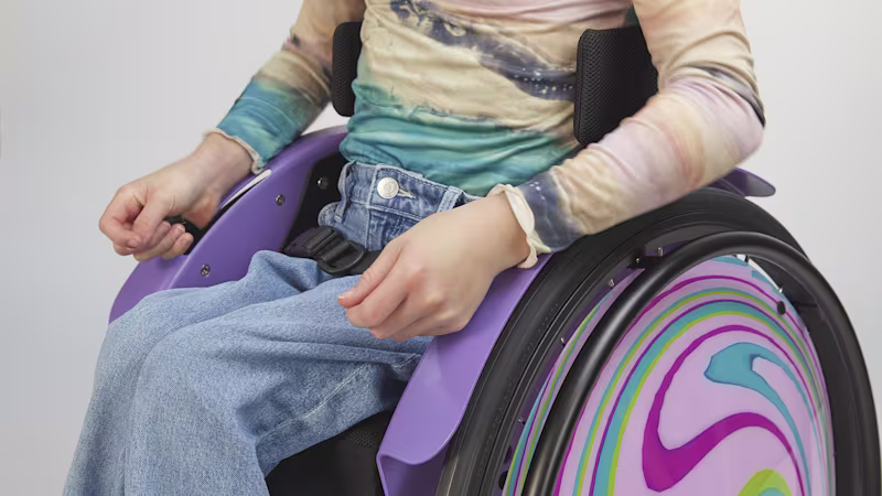 Close-up of a young girl in her purple Ottobock kidevo mini.t wheelchair with a strap.