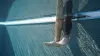 An underwater photo in a swimming pool of an Ottobock Evanto prosthetic foot and Genium X3 microprocessor knee and a natural leg. 