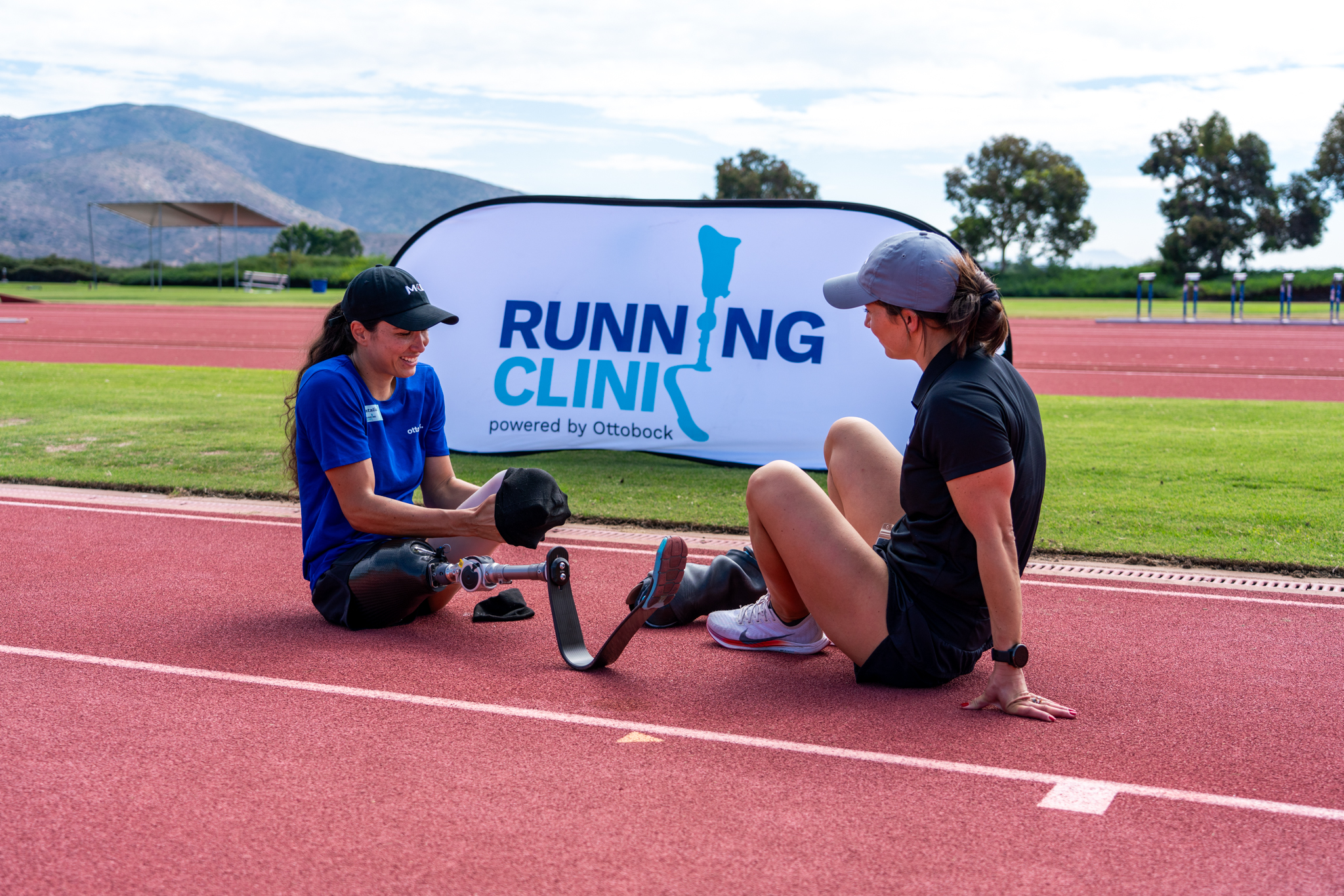 An amputee relaxing on an outdoor track with a Prosthetic Technician at the Ottobock Running Clinic