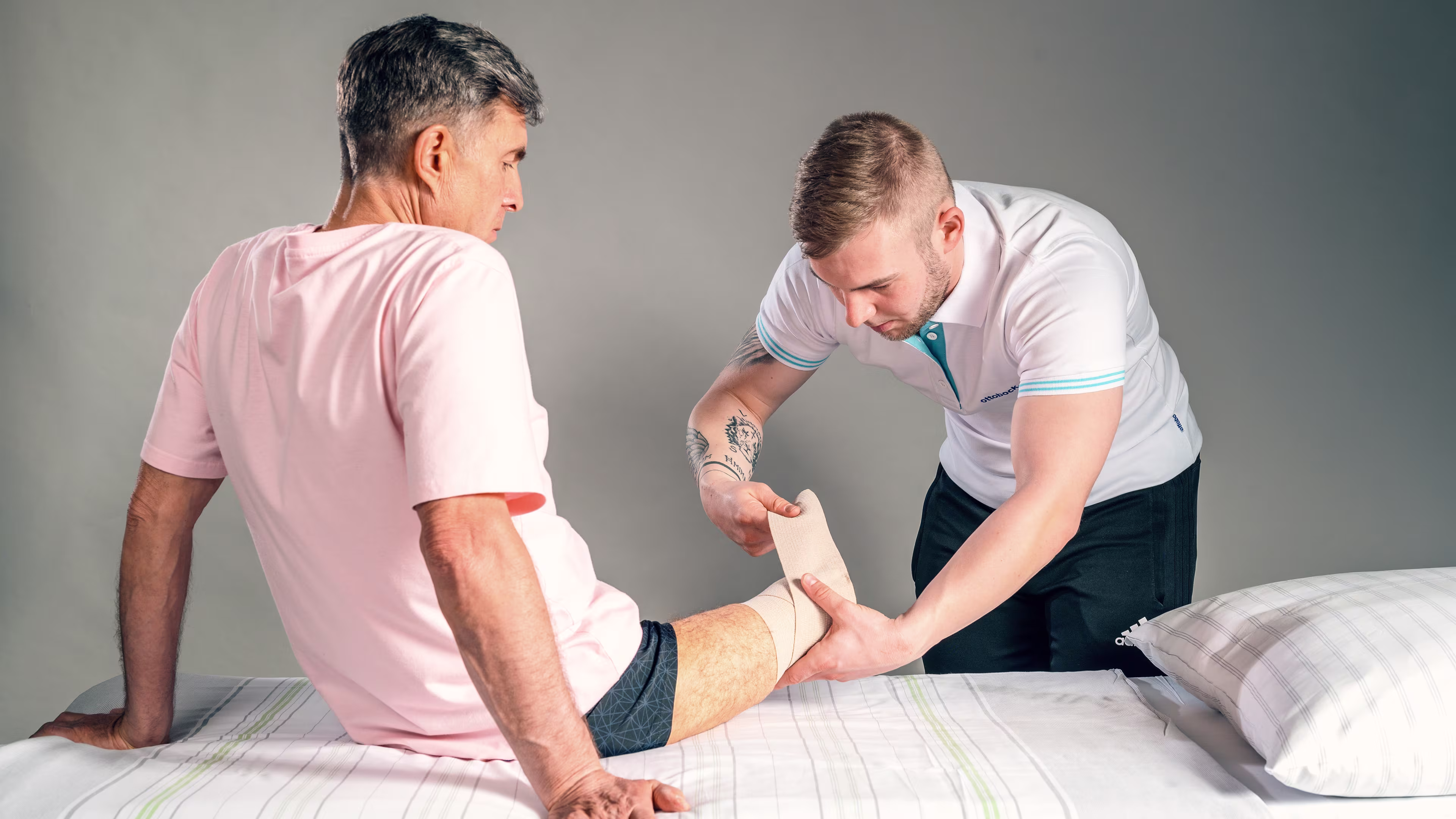 Prosthetist examines the residual limb and liner of a leg amputee with his hands.