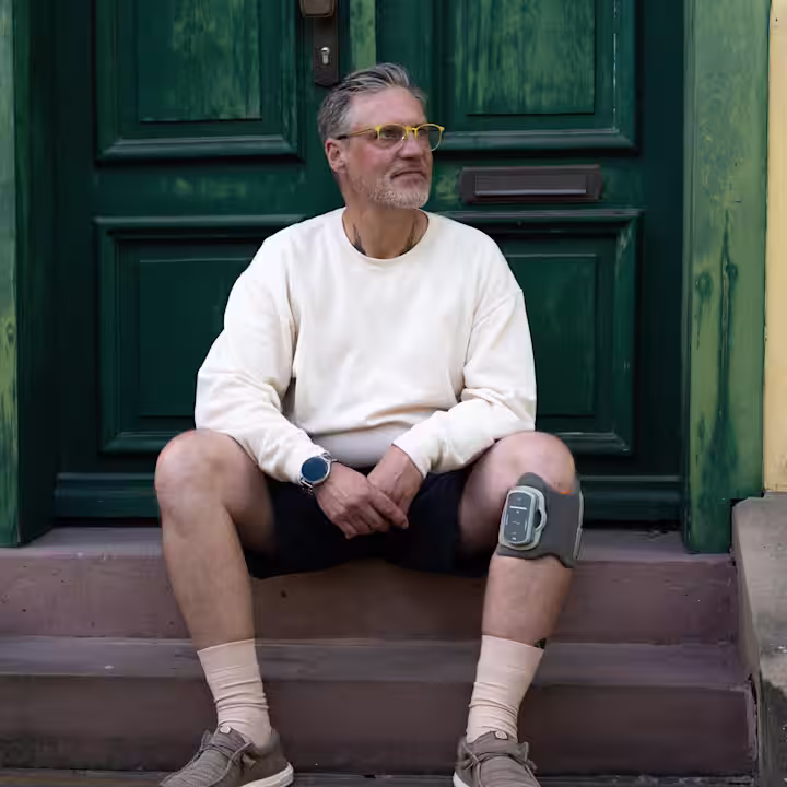 Ein Anwender mit dem L300 Go von Ottobock sitzt auf der Treppe und schaut hoffnungsvoll zur Seite.