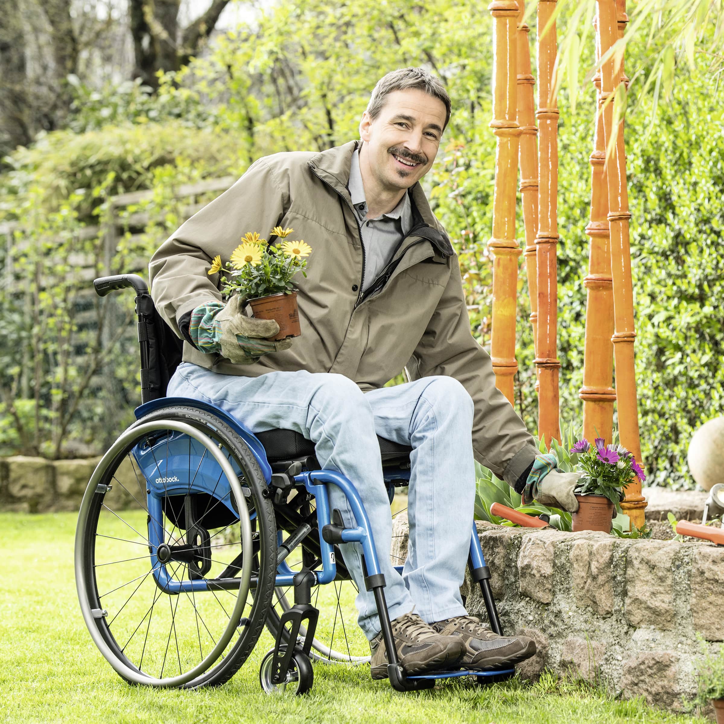 Wolfgang sitting in his blue Avantgarde 4 manual wheelchair whilst gardening. 