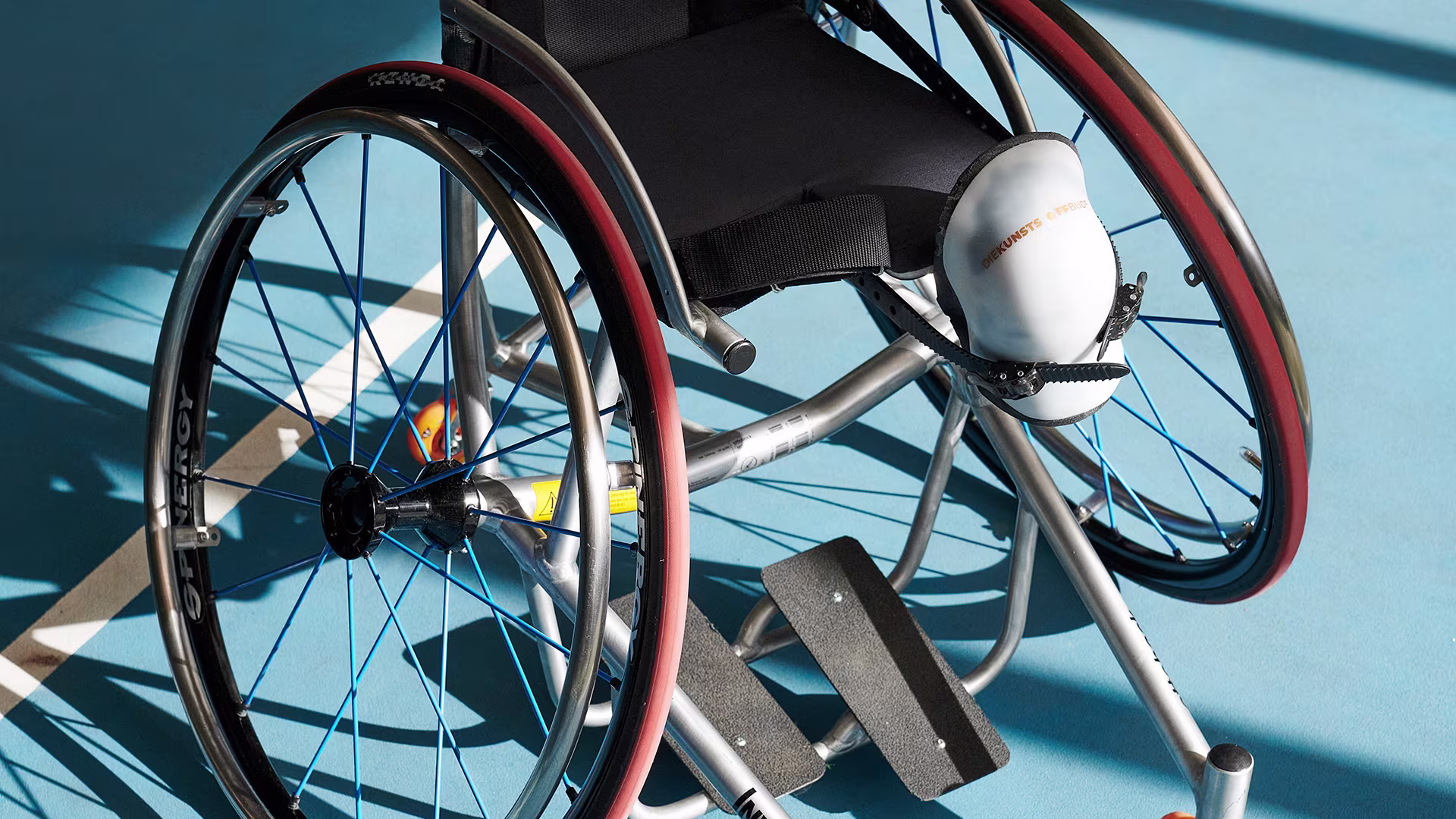 Front view of an Ottobock Invader tennis wheelchair on a tennis court