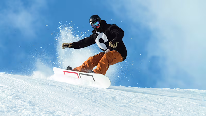 An adaptive athlete snowboarding down a mountain