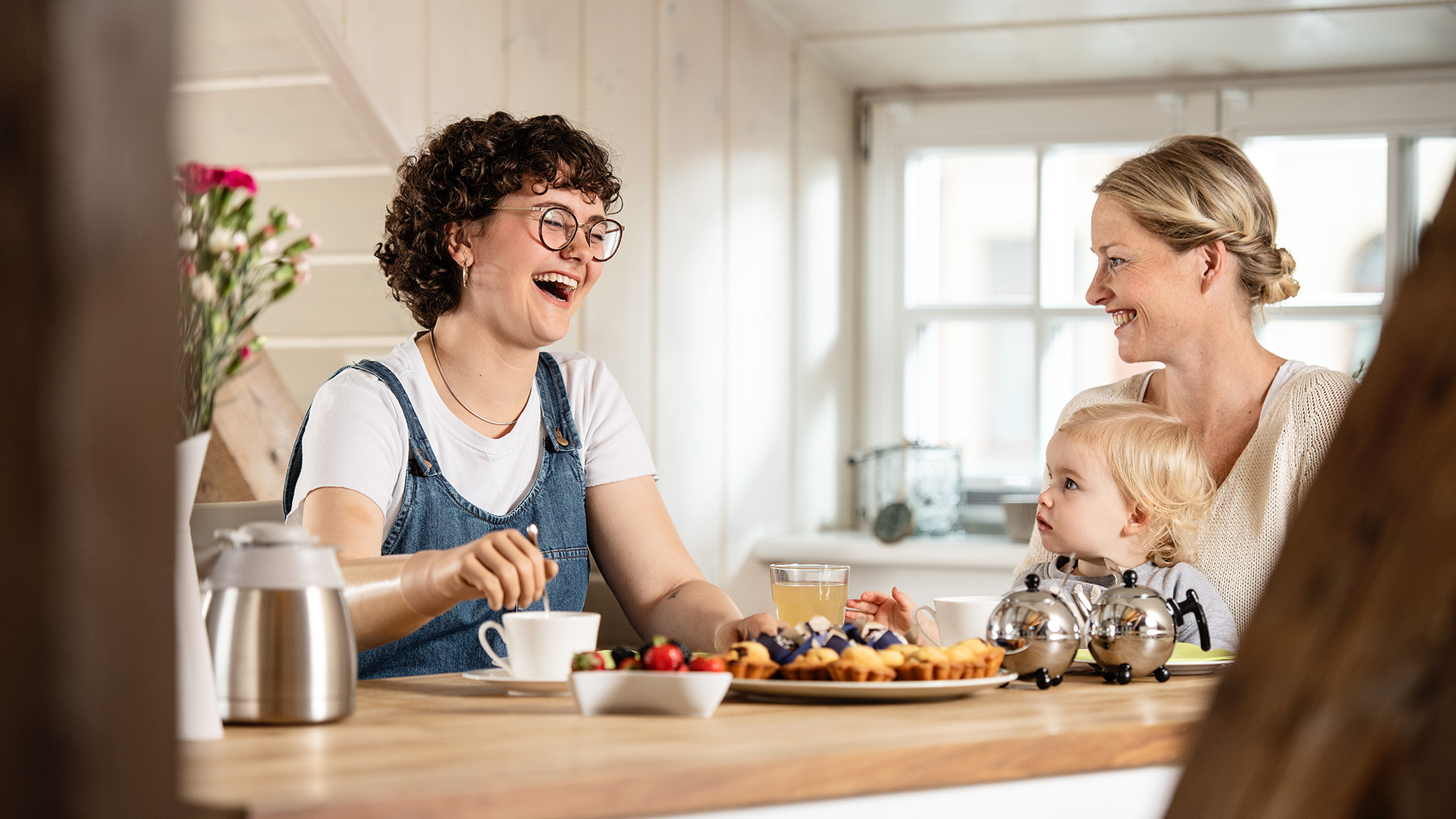 Lina uses her bebionic artificial hand to stir her tea while chatting with her friend during breakfast