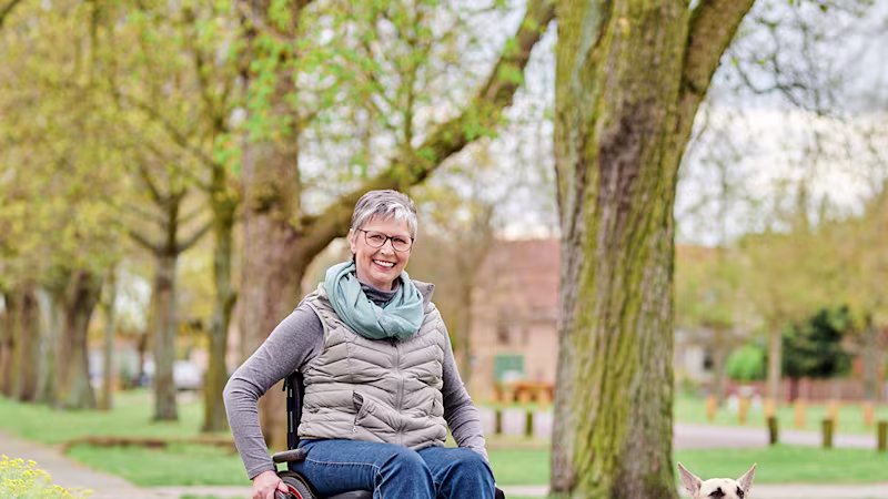 Wanda führt mit ihrem Rollstuhl ihren Hund aus.