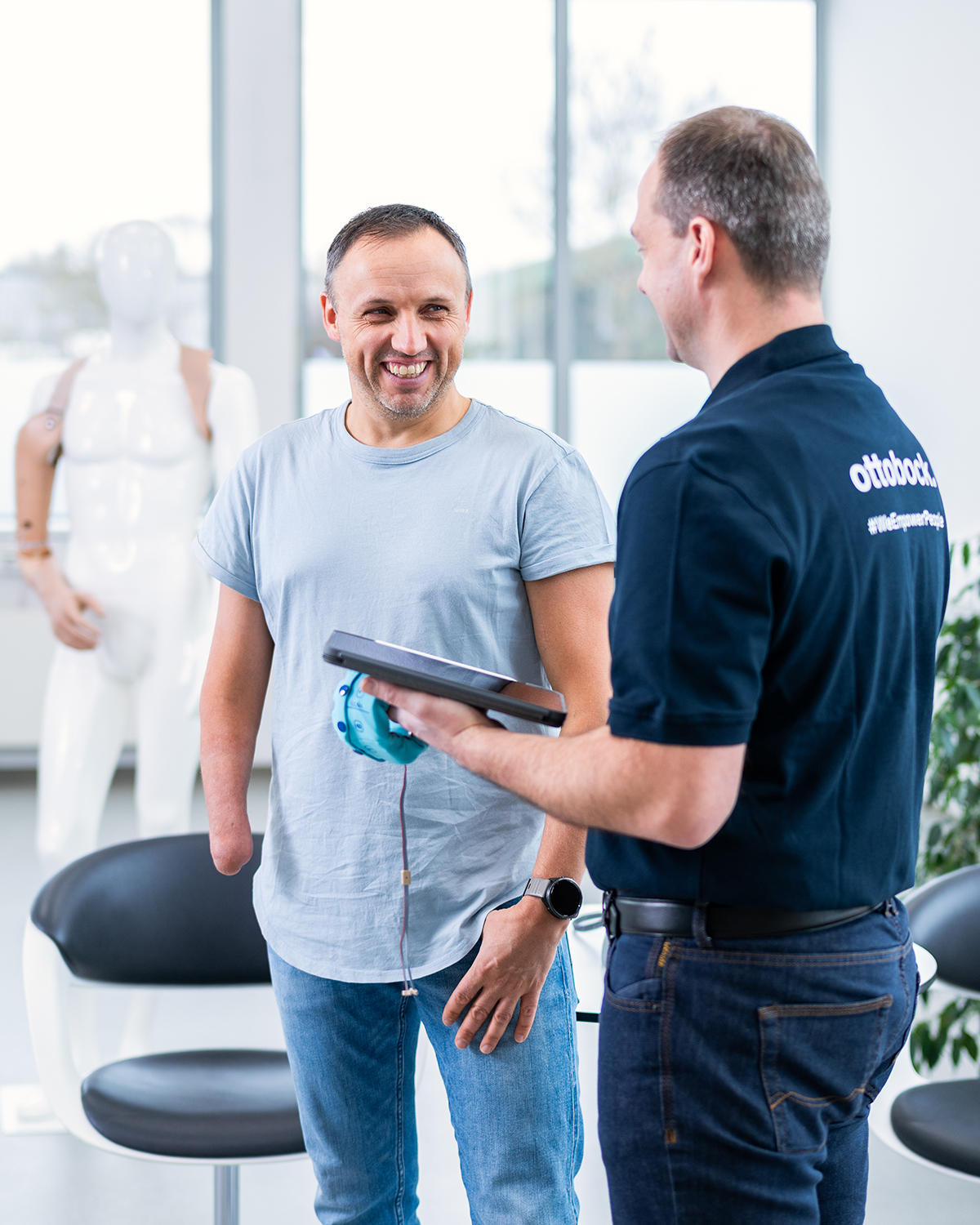 An orthopaedic technician and a prosthetic user discuss possible prosthetic fitting options.