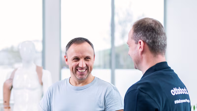 An orthopaedic technician and a prosthetic user discuss possible prosthetic fitting options.