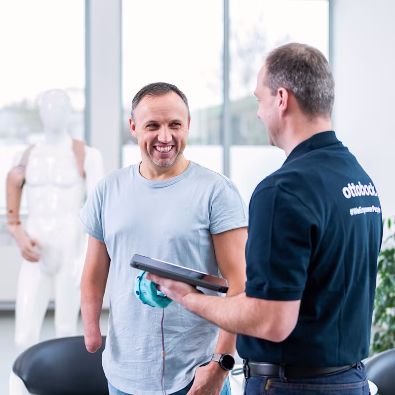 An orthopaedic technician and a prosthetic user discuss possible prosthetic fitting options.