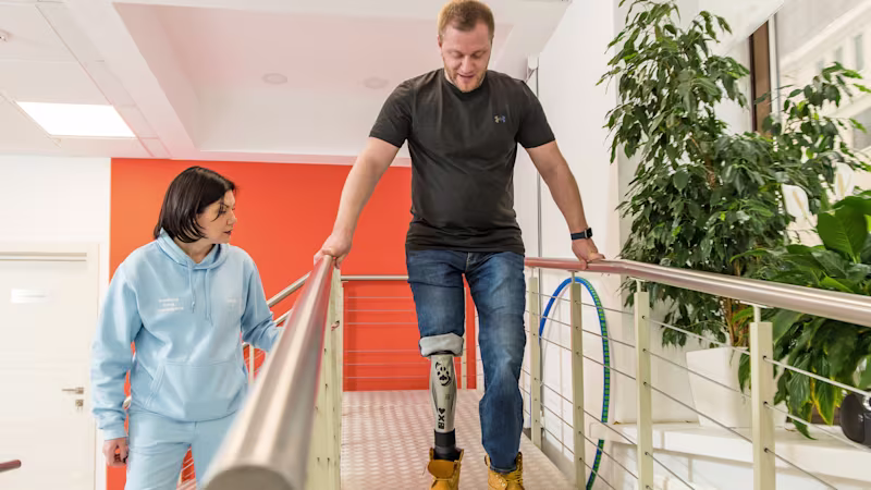 Пользователь с парной ампутацией спускается по рампе