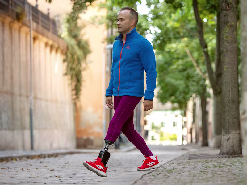 Un individuo masculino sin su pie izquierdo camina con confianza en su tobillo de Empower, una prótesis avanzada para veteranos.