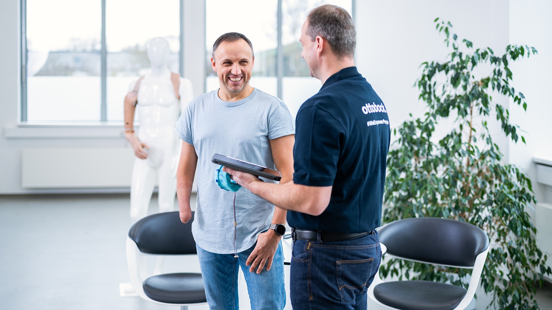 An orthopaedic technician and a prosthetic user discuss possible prosthetic fitting options.
