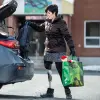 Une femme sortant les courses de sa voiture