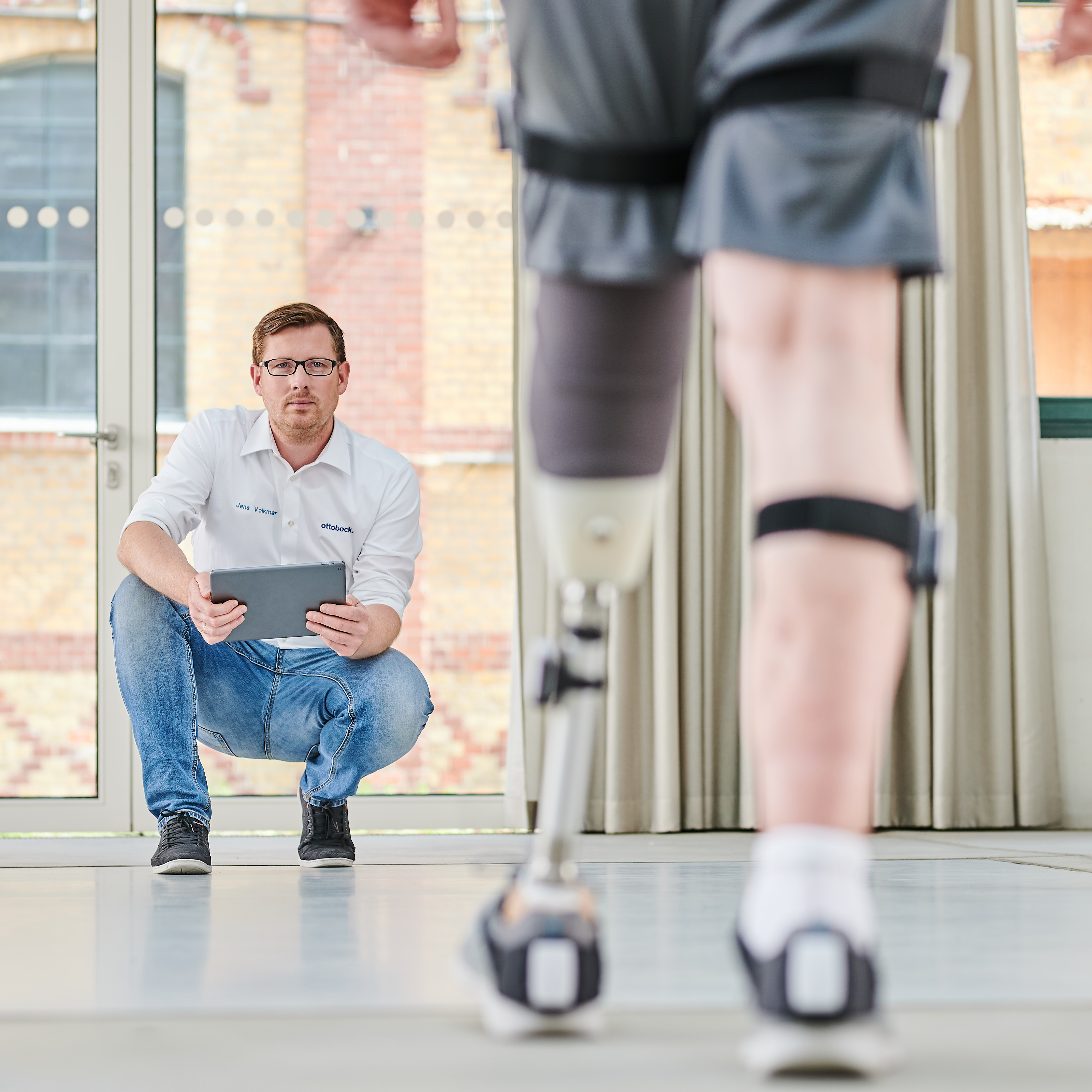 Специалист по реабилитации помогает пользователю протеза освоить навыки ходьбы.