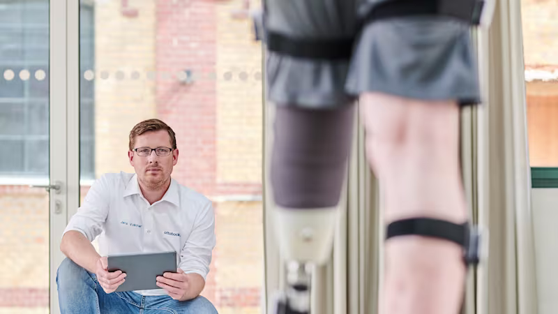 Специалист по реабилитации помогает пользователю протеза освоить навыки ходьбы.