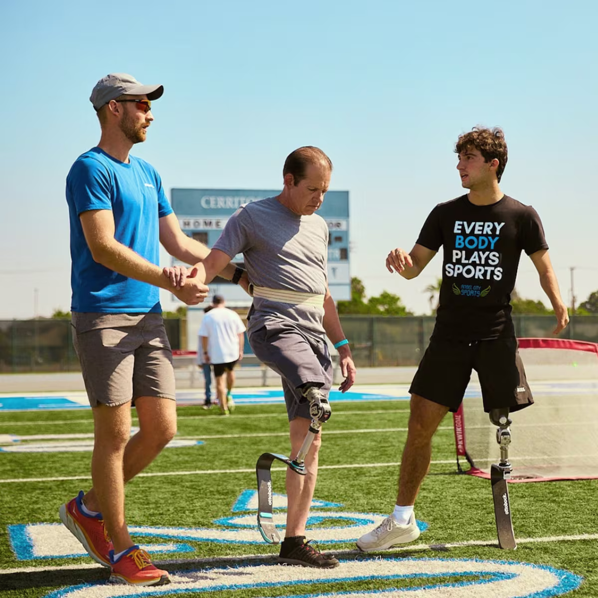 Ezra Frech and Full Circle Movement Coach Lucas Crisanti coordinating with an event attendee in an Ottobock prosthetic running blade