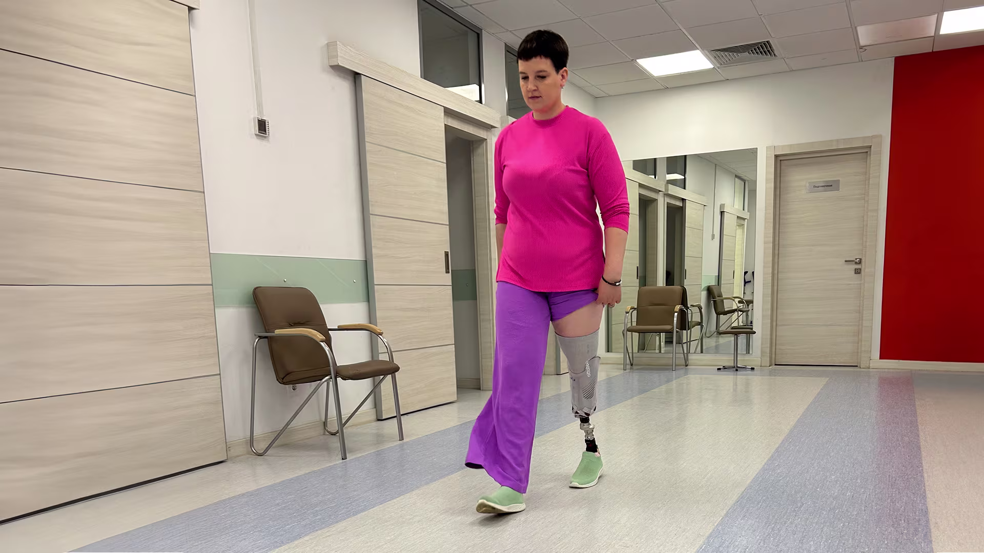 Девушка на протезе голени занимается в зале ходьбы Ottobock.