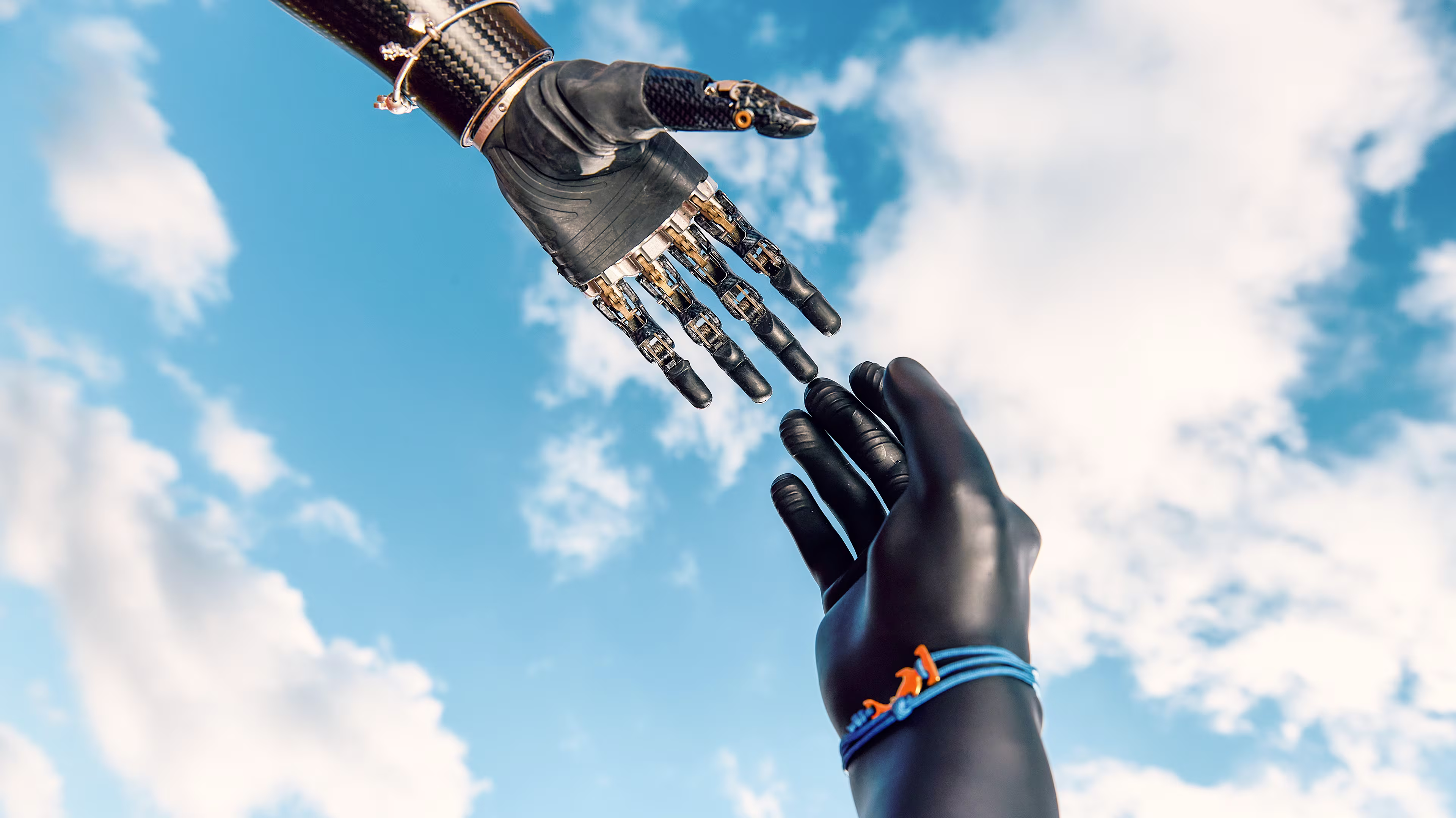 A prosthetic glove touches the tip of the finger of an Ottobock bebionic hand