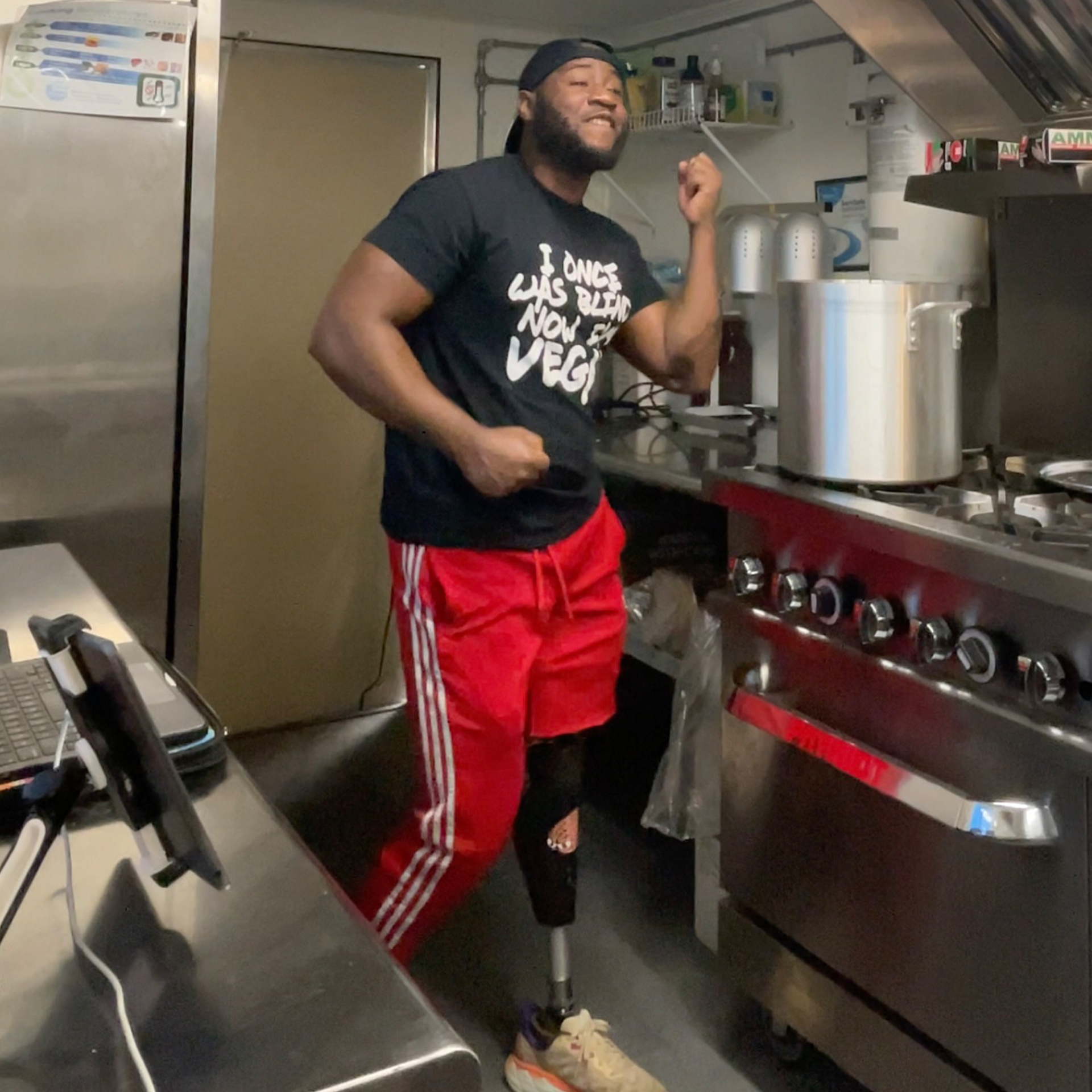 Man with a lower limb loss Brandon Todd wearing an Ottobock C-Leg microprocessor knee dances joyfully in the kitchen.