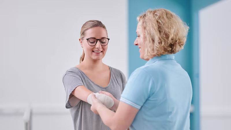 Eine Anwenderin bekommt von der Physiotherapeutin einen Kompressionsverband nach der Armamputation