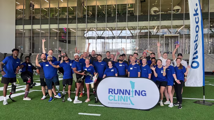 A group of amputee athletes, prosthetists, and orthotic & prosthetic professionals posing for a group photo at the Ottobock Running Clinic in Dallas, TX