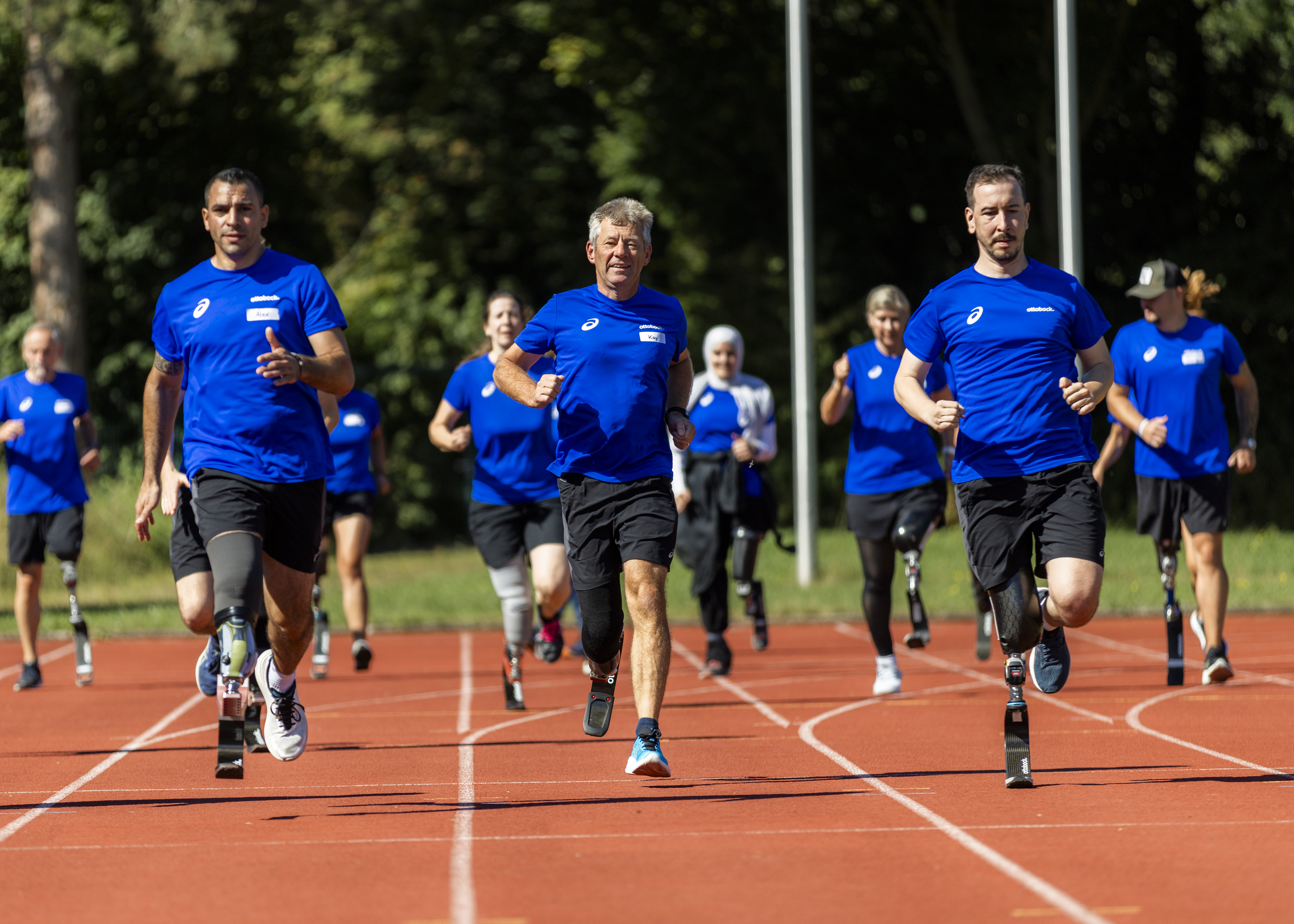 Group of runners with Ottobock prosthetic blades training together on an outdoor track