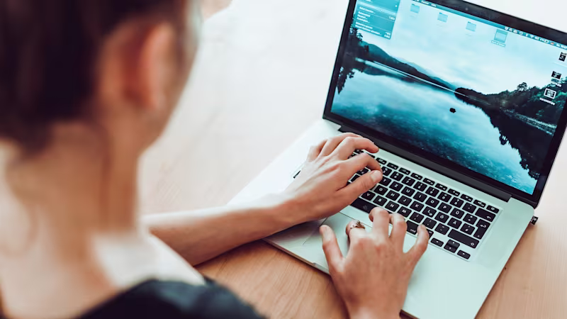Eine Frau sitzt am Laptop und sucht in der Expertensuche.