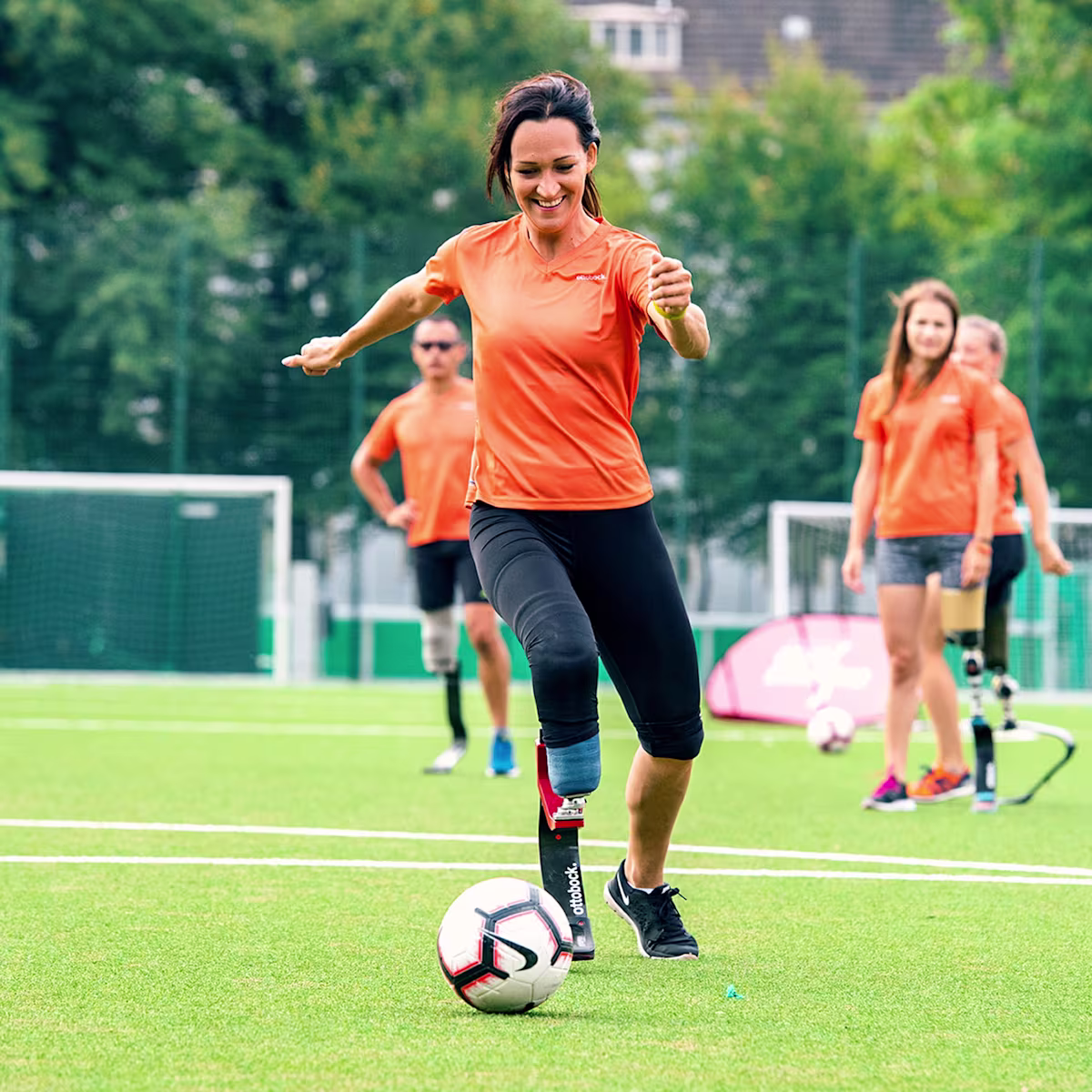 Una ragazza con protesi da corsa rincorre il pallone in una pausa delle Running Clinic