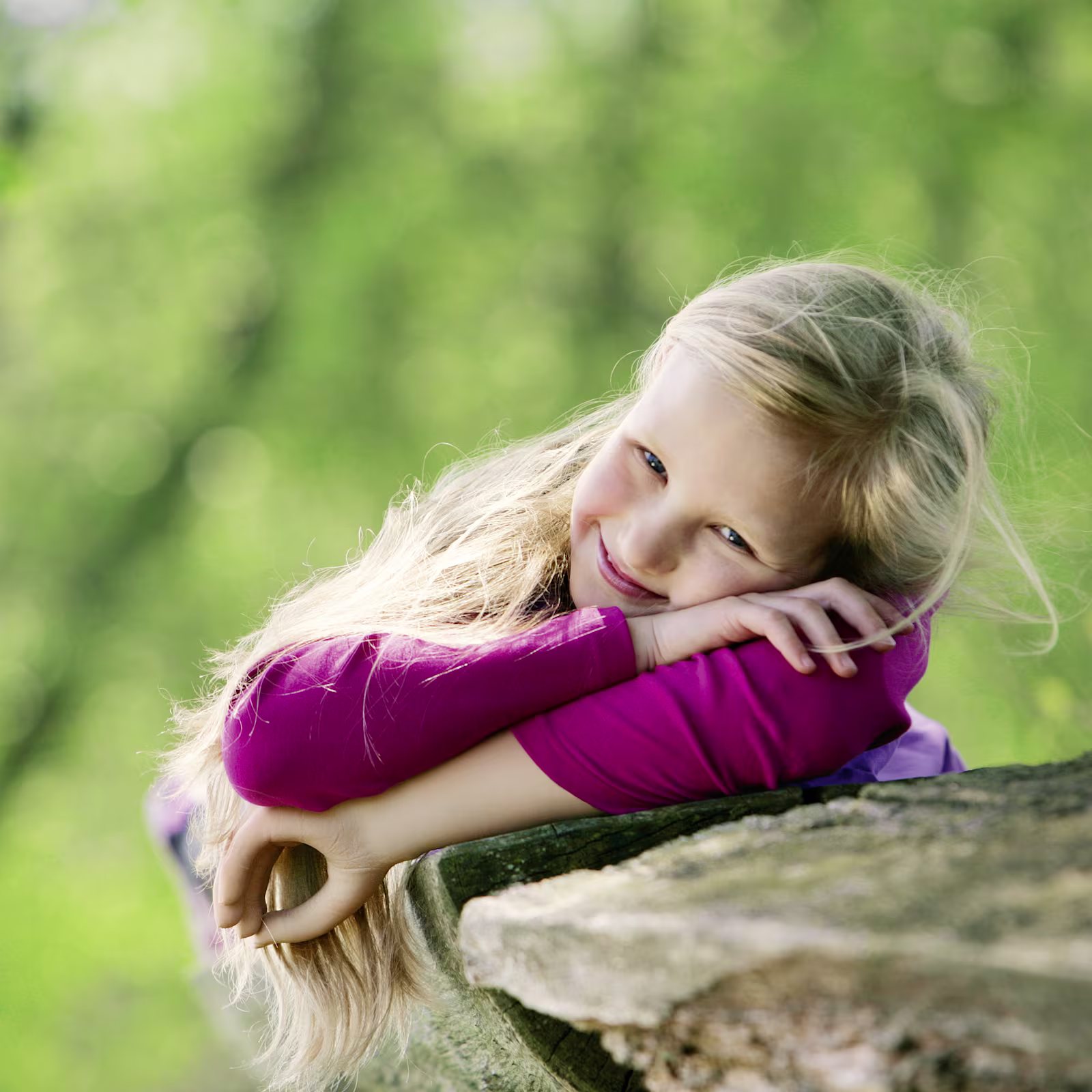 Girl with an Ottobock prosthetic hand smiling at the camera.