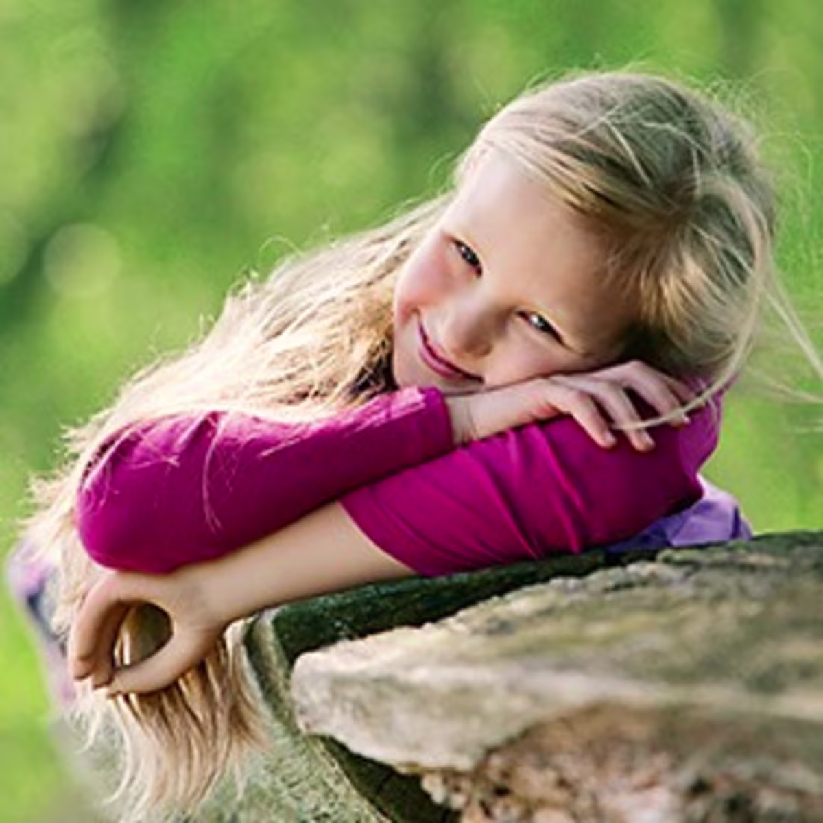 Girl with an Ottobock prosthetic hand smiling at the camera.