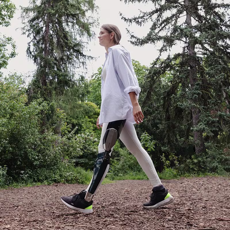 A women walking through a park with her Ottobock C-Brace