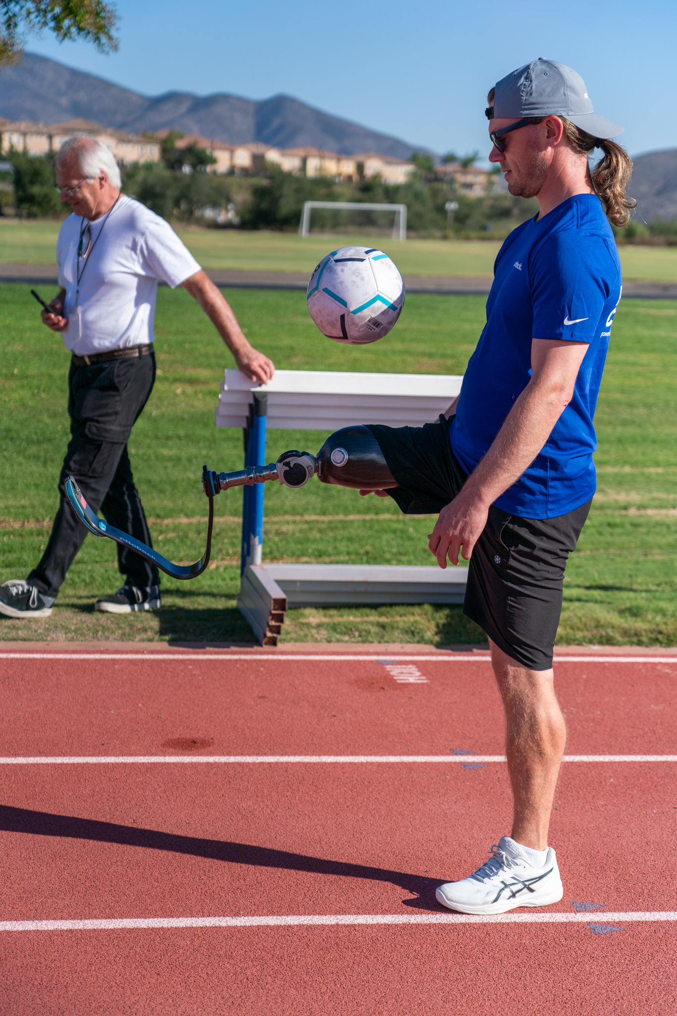 A leg amputee playing with a soccer ball on an outdoor track field in Chula Vista, CA