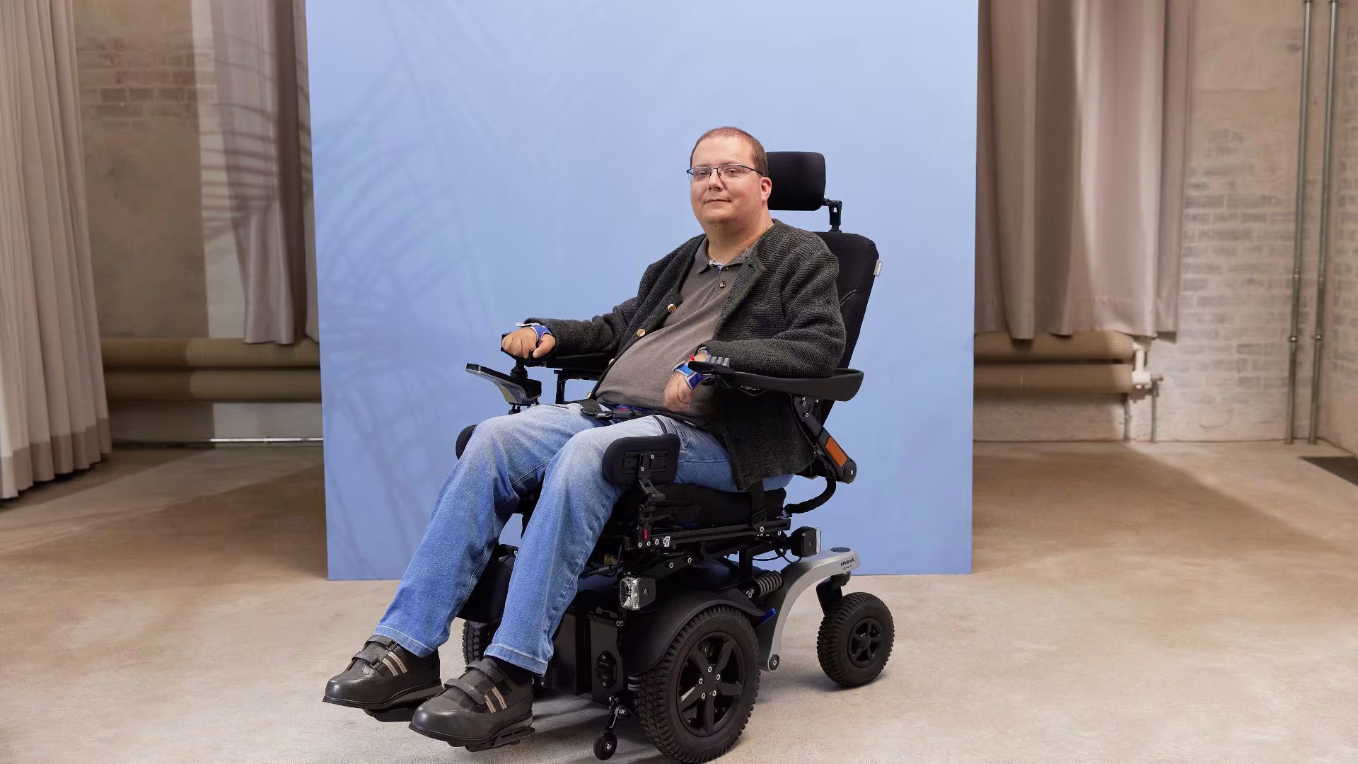 Tobias Juvo B7 tekerlekli sandalyesinde stüdyoda oturuyor.