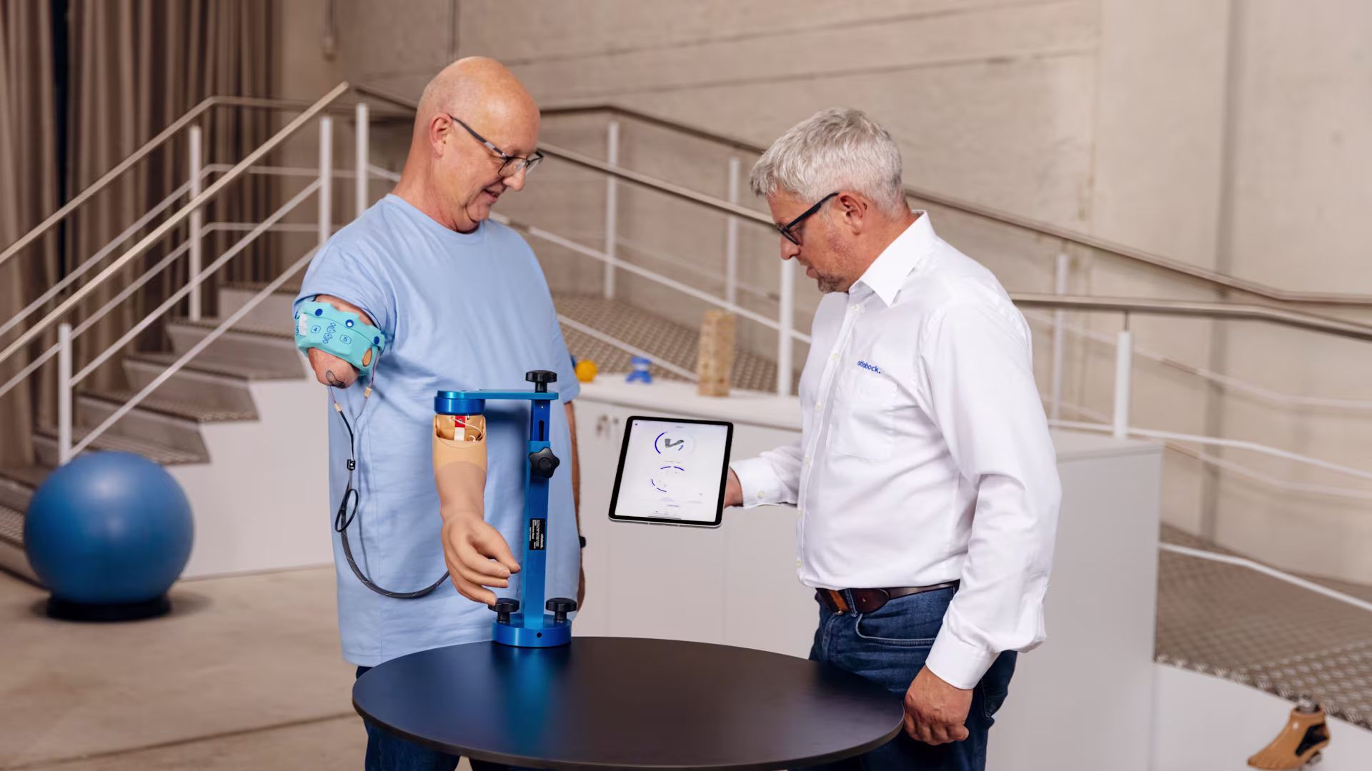 An orthopaedic technician and a prosthesis user test the functionality of the DynamicArm using the myosmart cuff and the connectgrip app.