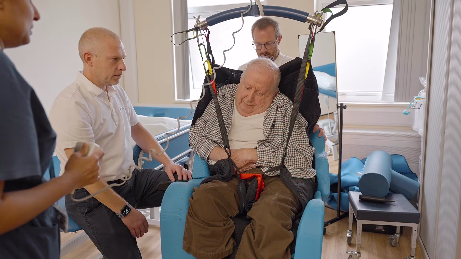 A man being hoisted into a custom foam wheelchair seat.
