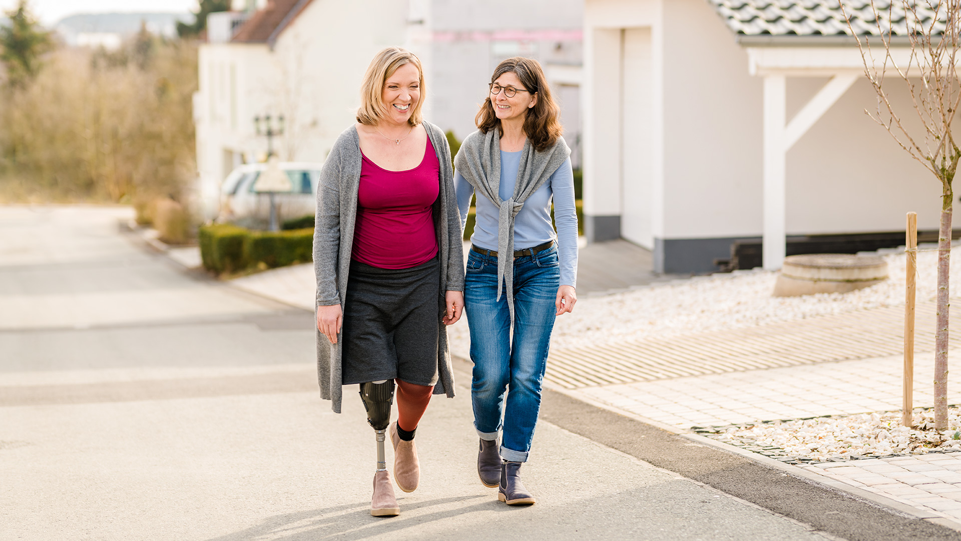 Two friends walk down the street in a good mood.