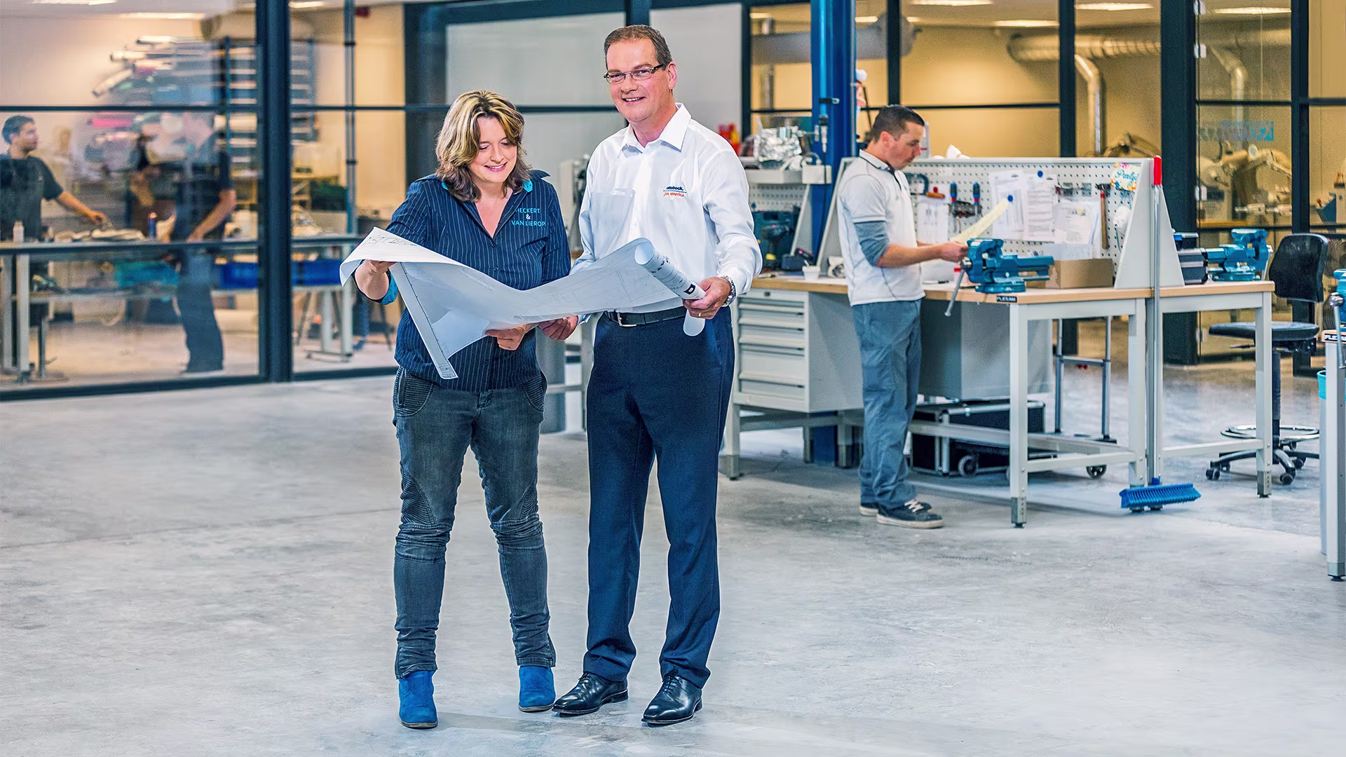 Ottobock consultant, discussing plans with customer in front of a workstation in orthopaedic workshop.