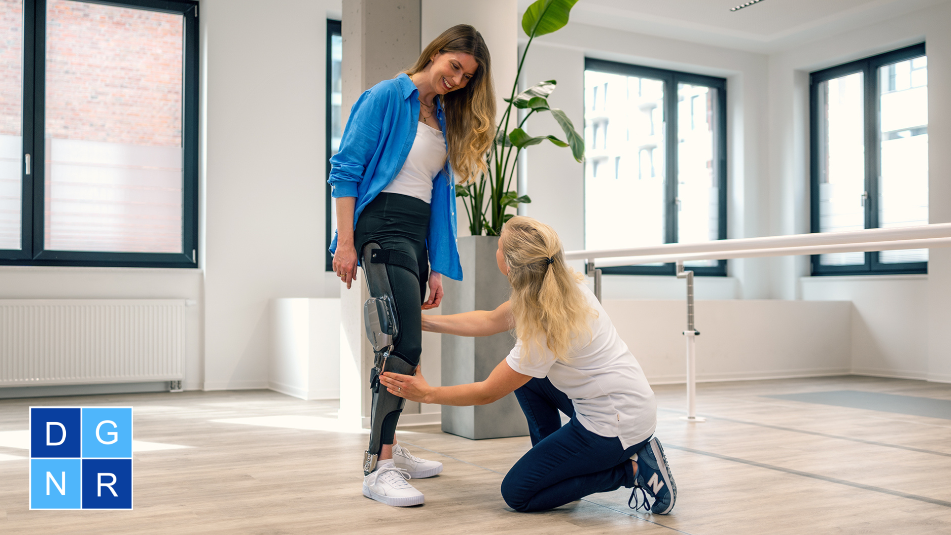 Eine weiblich gelesene Person trägt das C-Brace von Ottobock. Vor ihr kniet eine Therapeutin und justiert die Orthese.
