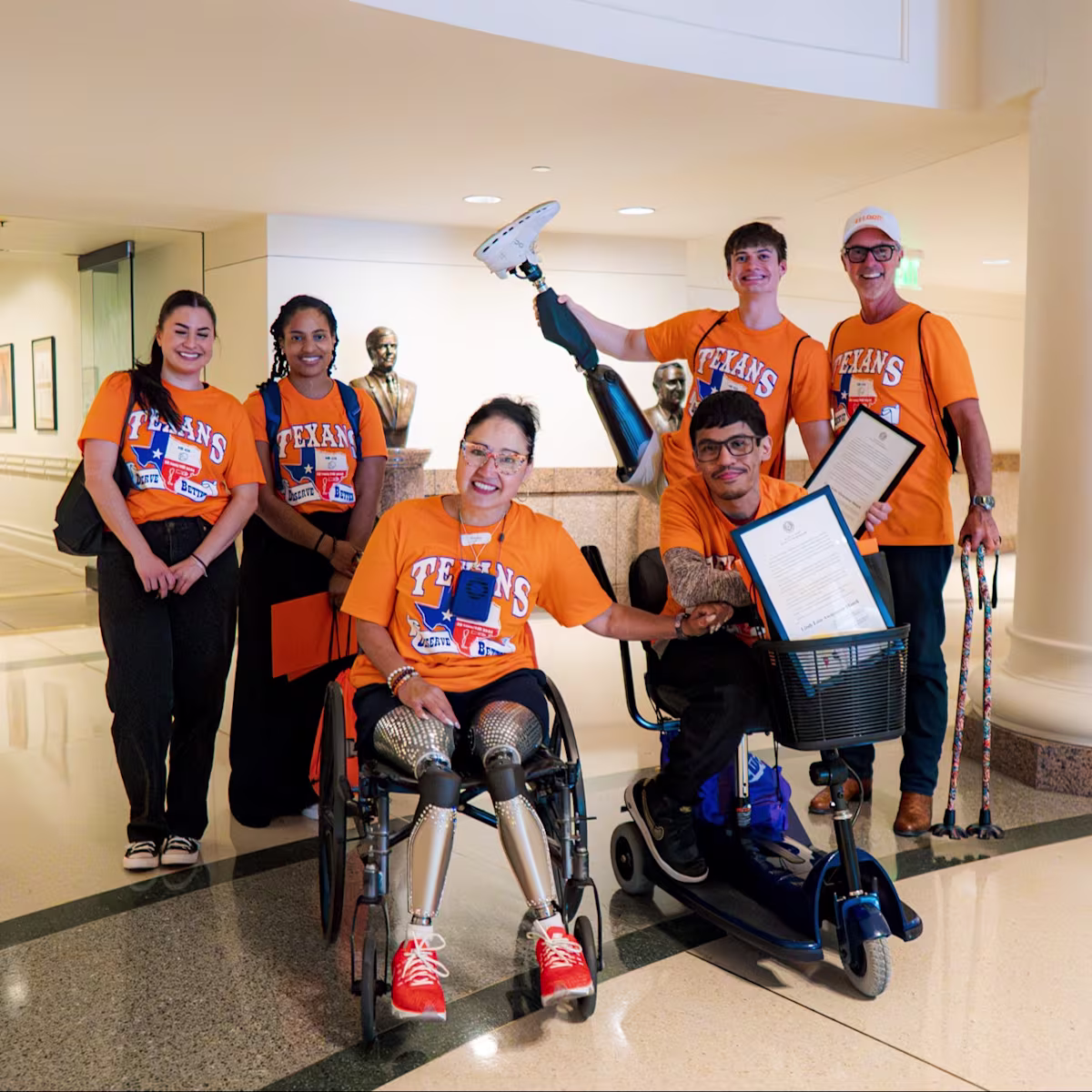 A group of differently-abled people wearing orange to represent Limb Loss and Limb Difference Awareness Month at Capitol Hill to advocate for a bill for their community
