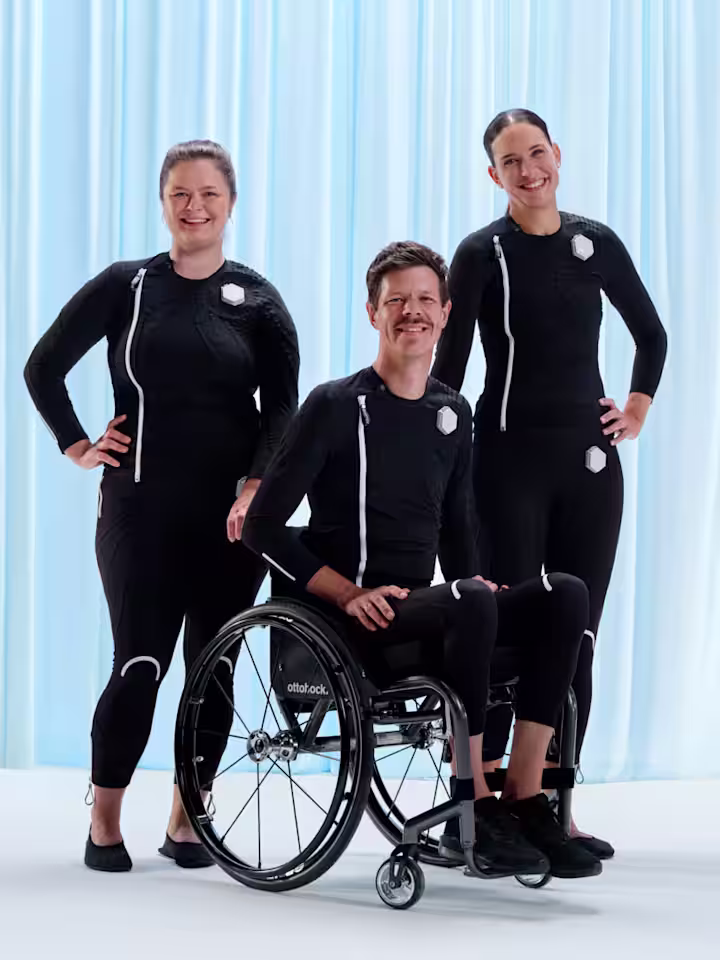 Ottobock users Lena, Ricky and Jacqueline stand and sit as a group in their exopulse suits.