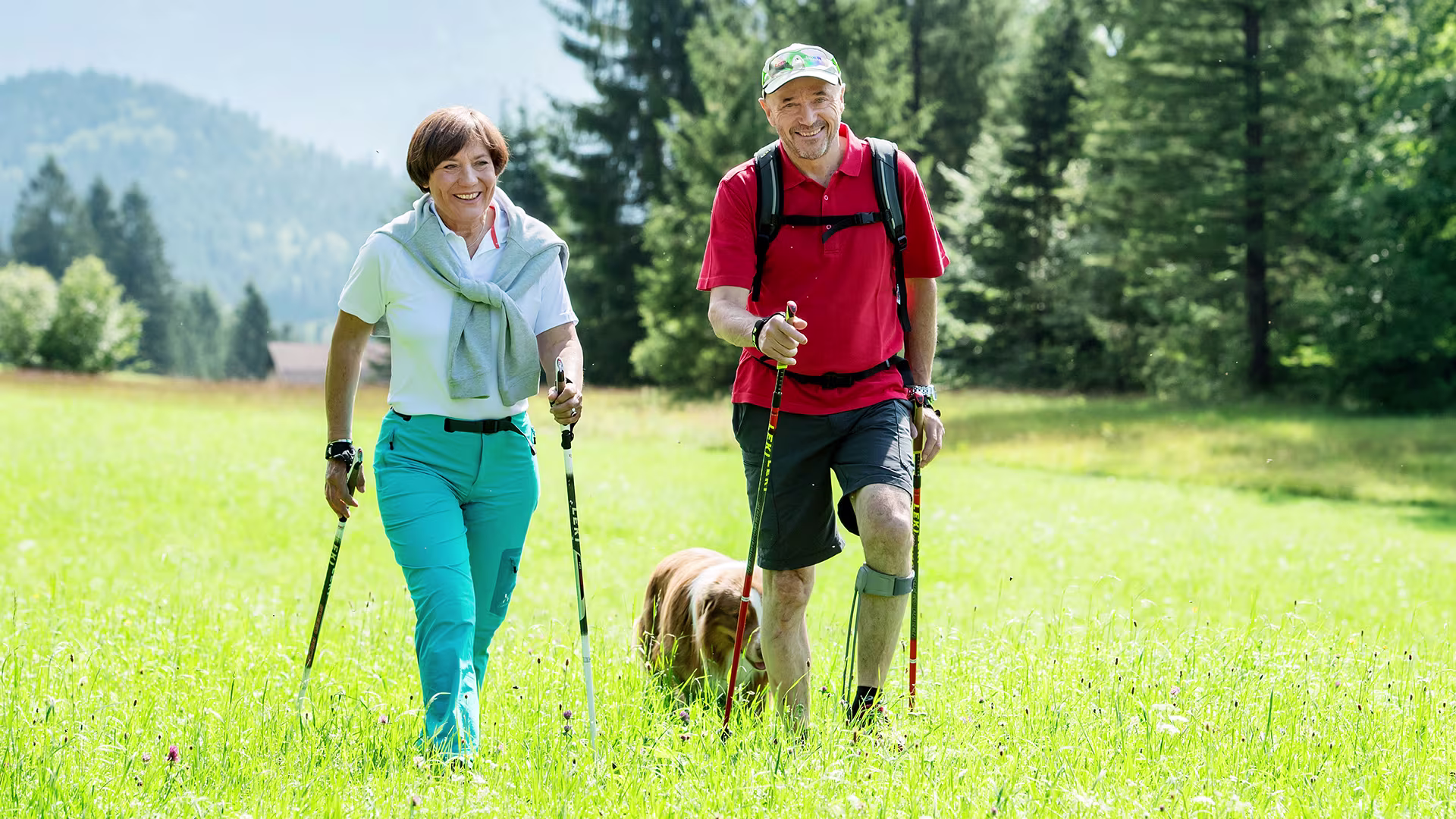 Elderly couple trekking with their dog through a field sporting the Agilium Freestep
