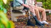 2 persone sedute su una panchina del parco, una persona indossa un ginocchio con microprocessore Ottobock Kenevo